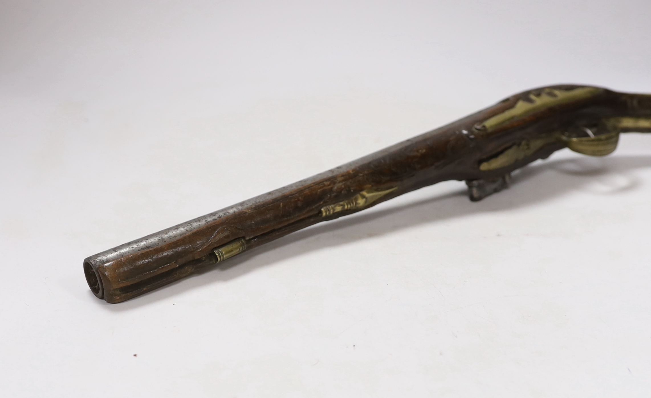 A Turkish Flintlock holster pistol with brass mounts, long spur butt cap, engraved lock and carved stock, barrel 29.5cm
